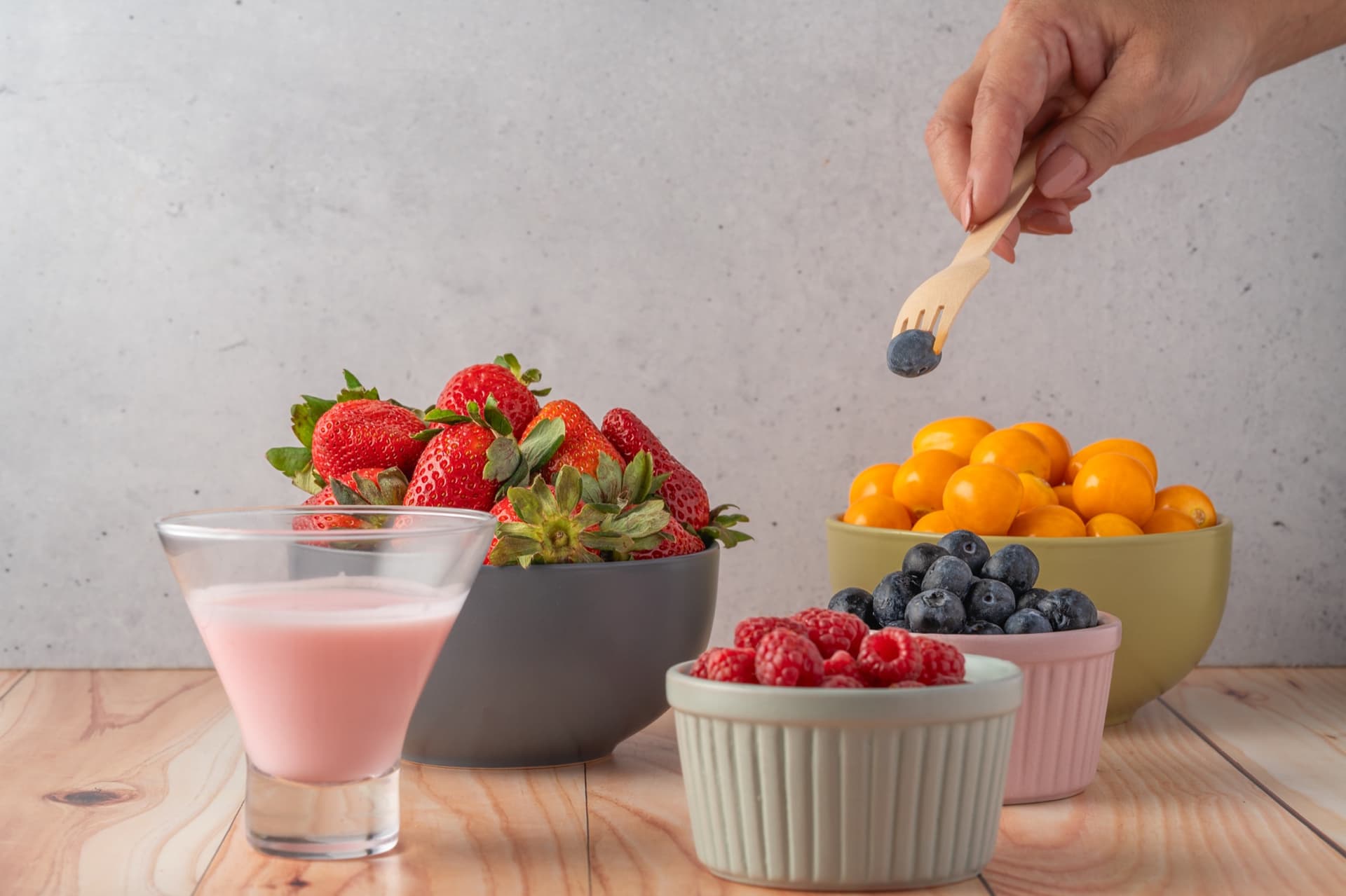Bowls of strawberries, raspberries, blueberries, and other fresh fruit