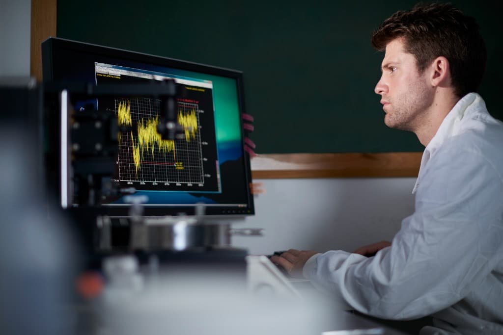 Scientist reviewing chromatographic peak traces on a laboratory monitor