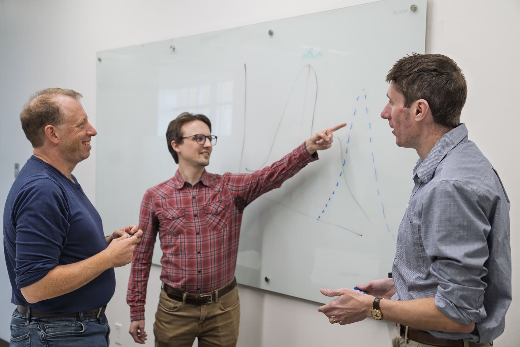 Ivan Baxter, Louis Connelly, and Allen Hubbard working through a chromatogram at a whiteboard